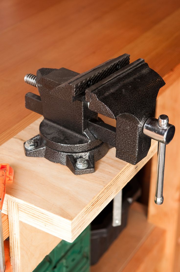 a bench vise is sitting on top of a workbench