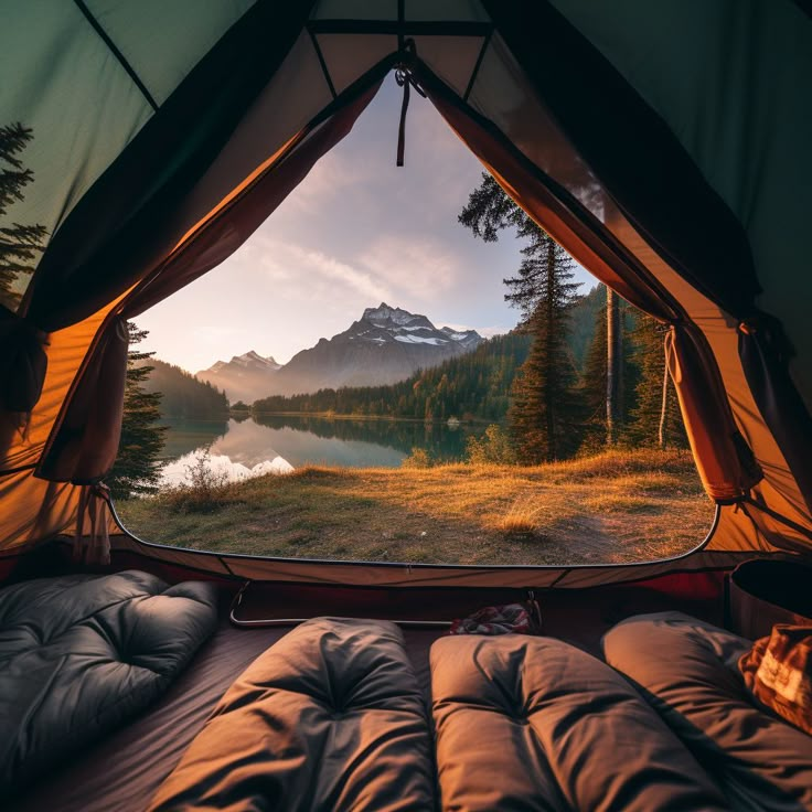 the view from inside a tent looking out at a lake and mountains in the distance