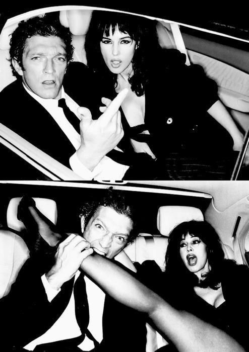 black and white photo of two people sitting in a car with one woman sticking her tongue out