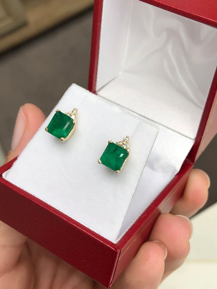 Elegance defined! These emerald and diamond earrings are fashioned in solid 14k yellow gold. These studs feature natural Asscher cut emeralds accented with natural white diamonds. The emeralds have a combined 2.81 total carat weight and a dark green hue that contrasts with the flashing fire of the diamonds. The brilliant round diamonds have a combined 11 points. Perfect for every day! Setting Style: Emerald & Diamond Studs Setting Weight: 2.0 grams Setting Material: 14K Yellow Gold Main Ston Gold Emerald Diamond Earrings, Elegant Green Diamond Earrings In 14k Gold, Emerald Yellow Gold Diamond Earrings Fine Jewelry, Fine Jewelry Green Diamond Earrings As Gift, Emerald Yellow Gold Diamond Earrings, Fine Jewelry Green Diamond Earrings For Gift, Anniversary Gold Diamond Earrings With Emerald, Green Emerald Cut Diamond Earrings For Anniversary, Emerald Cut Green Diamond Earrings For Anniversary