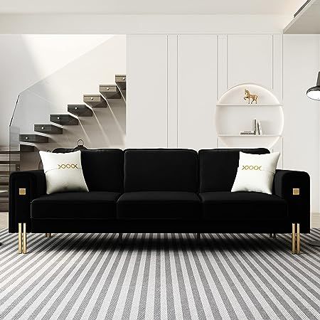 a black and white living room with stairs in the backgrounge, carpeted floor