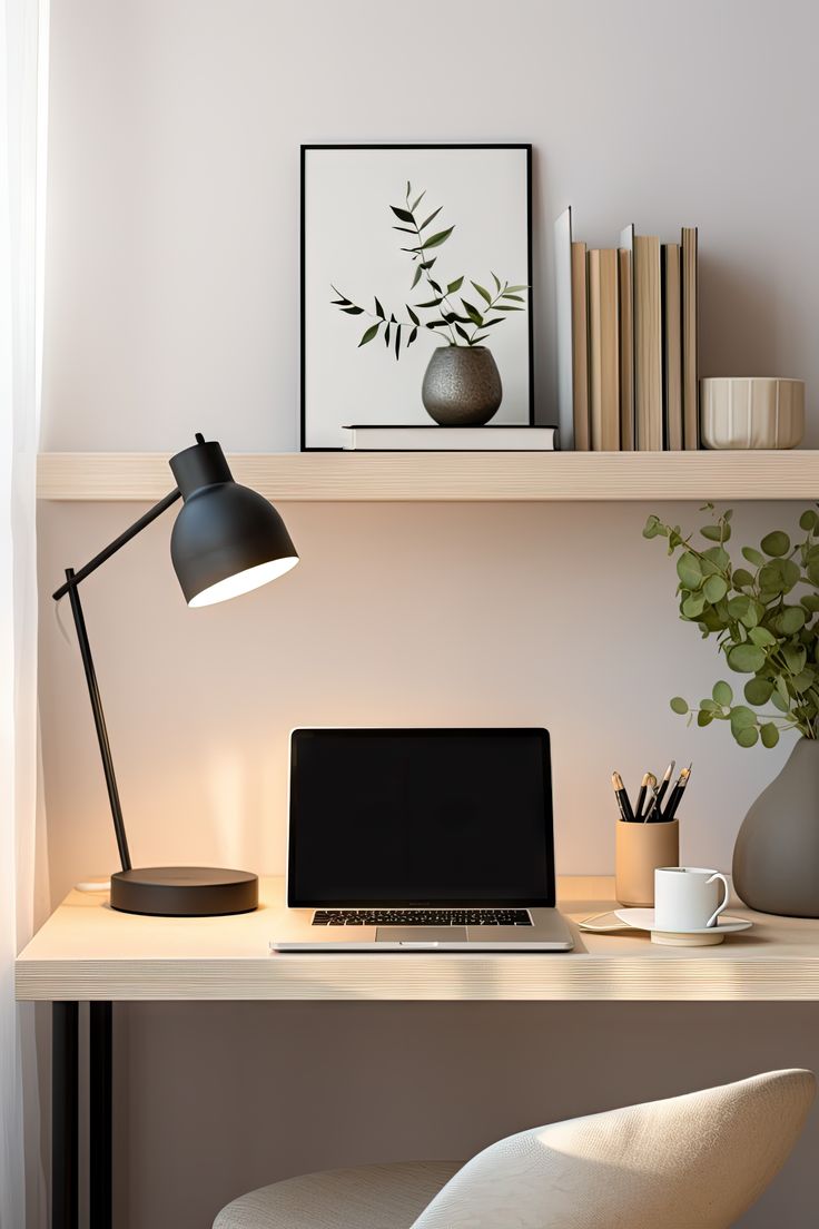 a laptop computer sitting on top of a wooden desk next to a lamp and potted plant