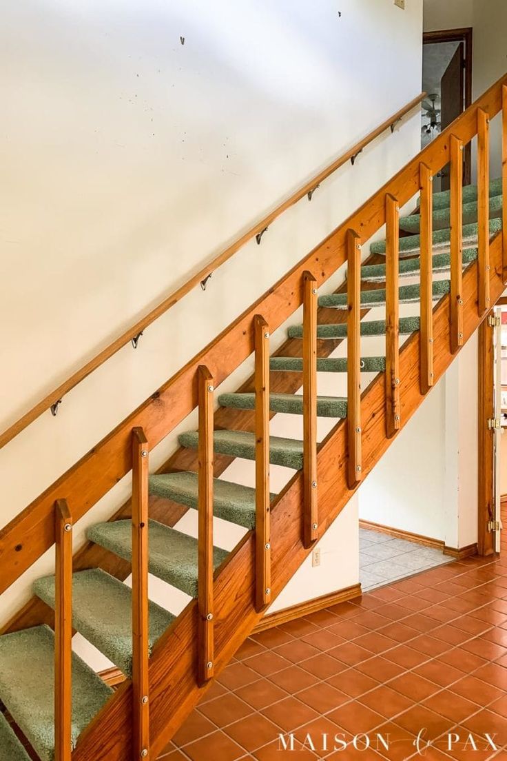 the stairs are made of wood and have green carpet