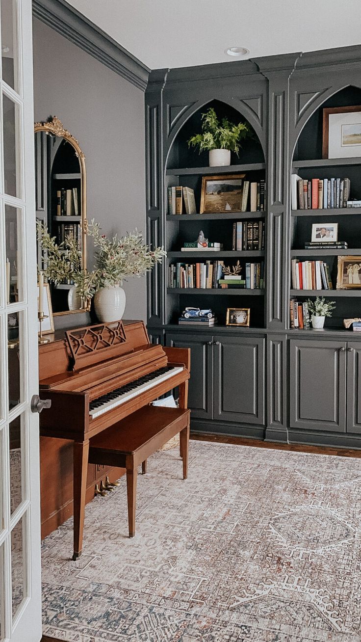 a grand piano sitting in front of a bookshelf