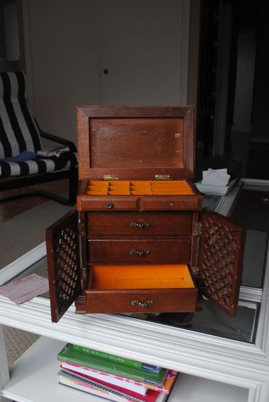 an old wooden chest with many drawers on it's sides and some books in the bottom drawer