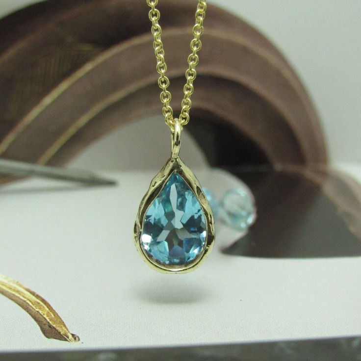 The Necklace And The Pendant Made From 14 Karats Solid Yellow Gold. Chain Length 17.7inch/ 45cm'. Aquamarine Stone House: 0.5x0.6inch/ 12x15mm'. Necklace For Women. Necklace For Men. Special Gold Necklace Bezel Set With A Pear-Shaped Blue Aquamarine. Hand-Made One Of A Kind. This Necklace Is So Simple, Delicate, And Timeless, A Gift That Each Woman Likes To Have. Chain Available In All Sizes, Color Gold And Karat, And Matte Or Shining Finish. Each Pendant Is Custom-Made, Unique, And Will Have Sl Blue Topaz Drop Necklaces, Blue Drop Necklaces With Blue Topaz, Gold Blue Topaz Teardrop Pendant, Blue Teardrop Pendant Necklace With 17 Jewels, Luxury Blue Teardrop Pendant Necklace, Yellow Gold Teardrop Blue Topaz Necklace, Blue Teardrop Necklace With 17 Jewels, Blue Briolette Necklace For Anniversary, Yellow Gold Drop Gemstone Necklace