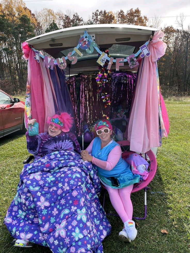 two women sitting in the back of a car decorated with decorations and streamers on it