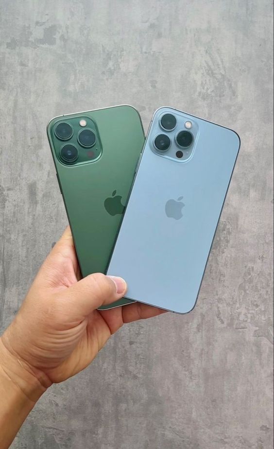 two new iphones are being held in their hands, one is green and the other is blue