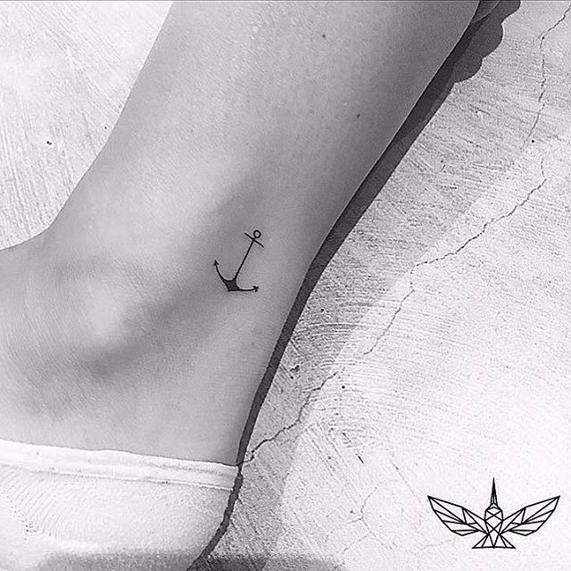 a small anchor tattoo on the ankle is shown in this black and white photo,