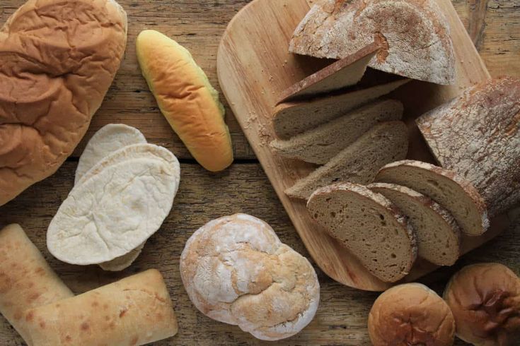 breads and pastries are arranged on a cutting board