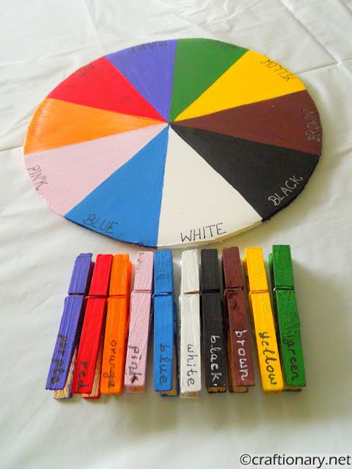 a wooden wheel with different colors and words on it next to some crayons