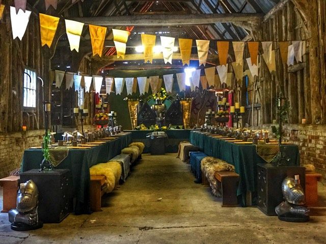 an old building with many tables and chairs in it's center aisle, decorated with flags hanging from the ceiling