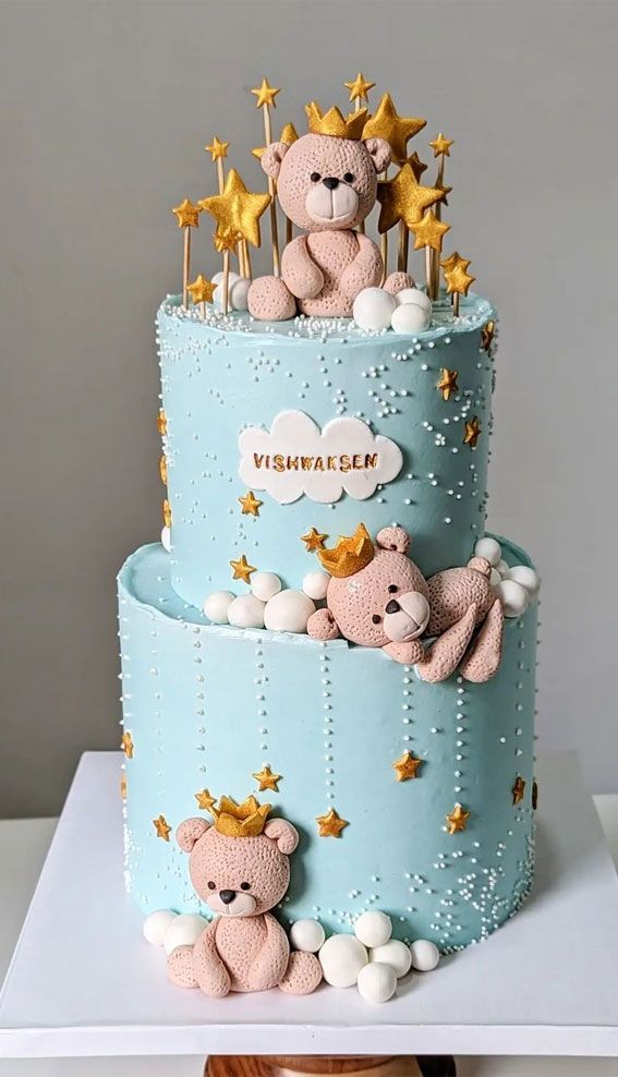 a three tiered cake decorated with teddy bears and stars