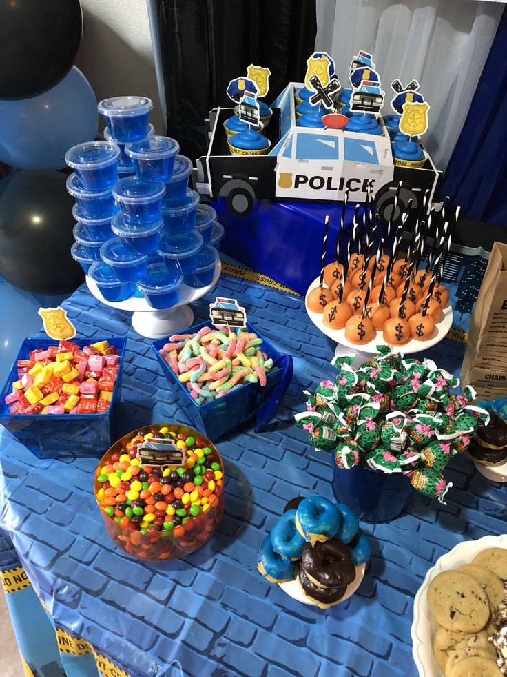 a blue table topped with lots of desserts and candies on top of it