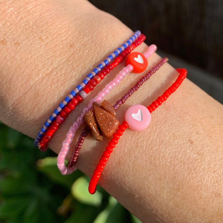 seed bead bracelet with a cute heart bead. red with pink heart. neon pink with red heart. strung on elastic please gently roll off and on to prolong its life handmade in venice, ca Red Adjustable Friendship Bracelets With Heart Beads, Adjustable Red Friendship Bracelets With Heart Beads, Adjustable Red Heart Bead Bracelet, Adjustable Red Heart Bracelet With Heart Beads, Red Hand-strung Friendship Stretch Bracelet, Red Heart Beads Friendship Bracelets For Valentine's Day, Red Friendship Bracelets With Heart Beads For Valentine's Day, Red Heart Beads Bracelet For Friendship, Red Heart Beads Friendship Bracelets