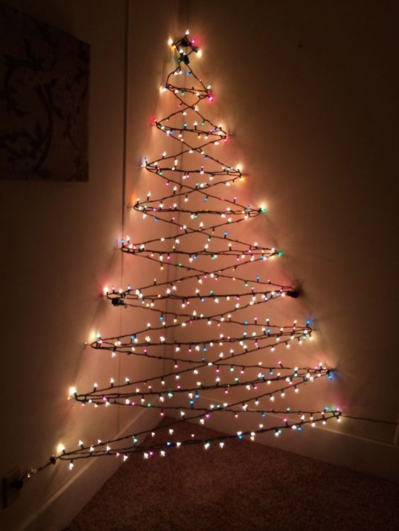 a lighted christmas tree in the corner of a room with lights on it's branches