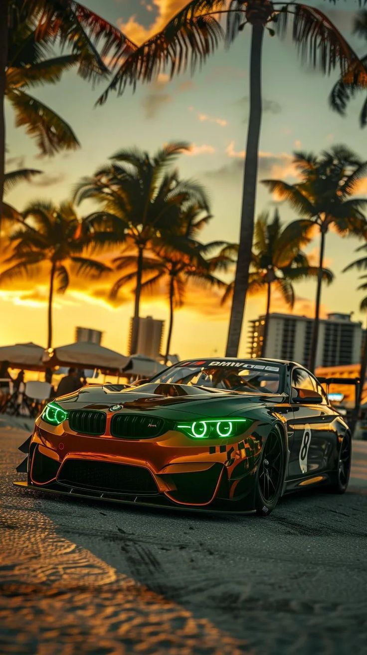 an orange and green sports car parked in front of palm trees on the beach at sunset