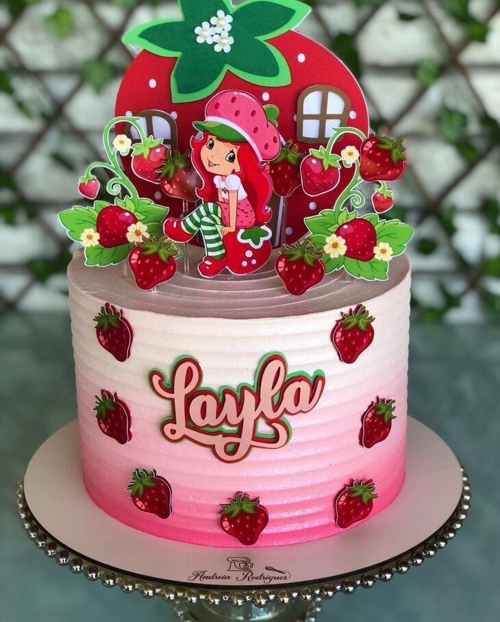 a strawberry shortcake cake with strawberries on top and the word love spelled in english