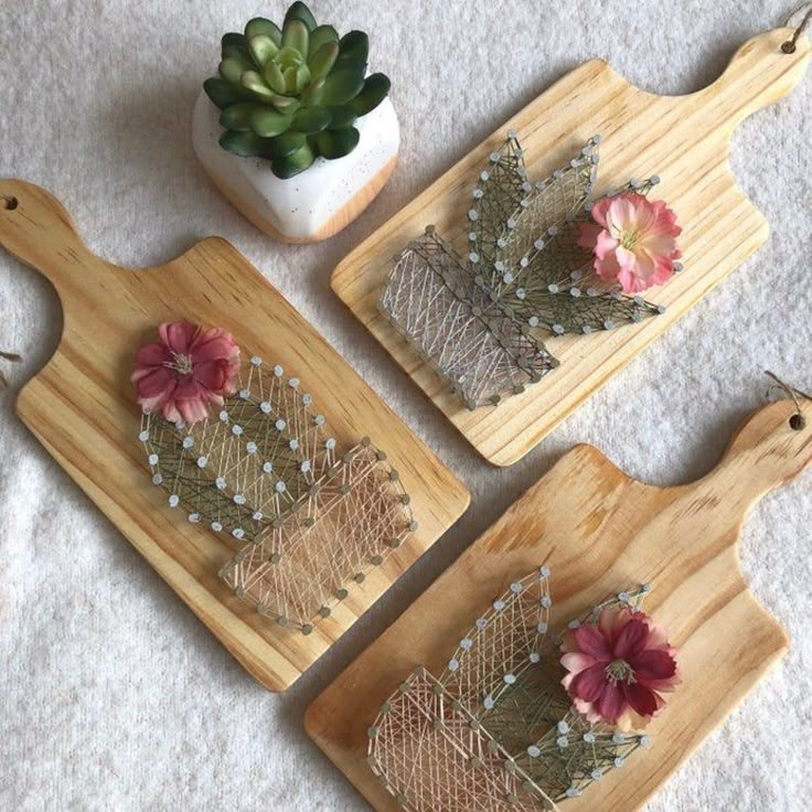 three wooden trays with flowers on them and a succulent plant in the middle