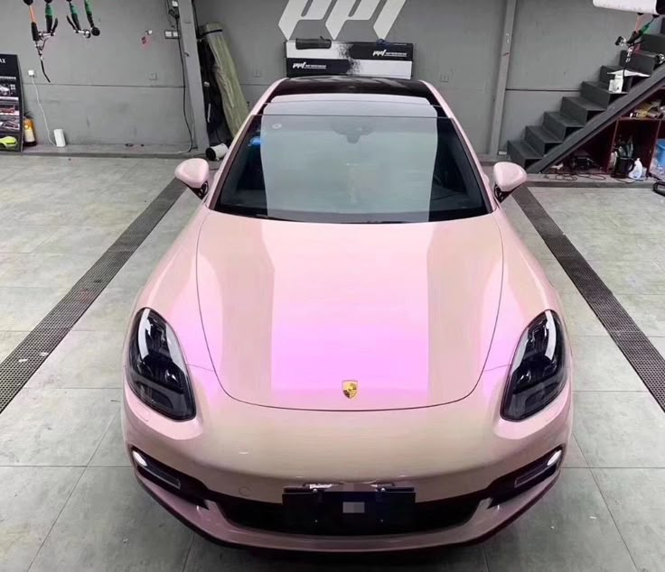 a pink sports car parked in a garage