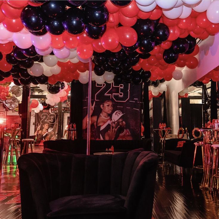 a room filled with black and red balloons