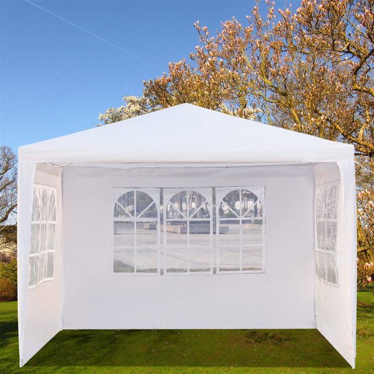 a white tent with windows on the grass