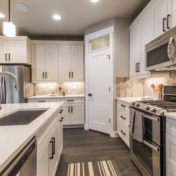 a kitchen with white cabinets and stainless steel appliances