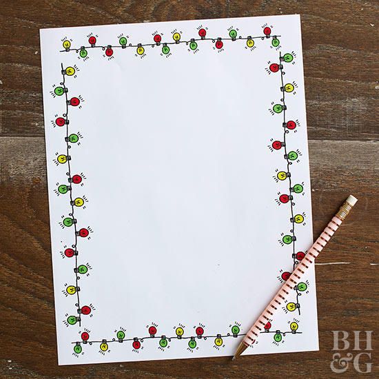 a piece of paper with christmas lights on it next to a pencil and ruler sitting on a wooden surface