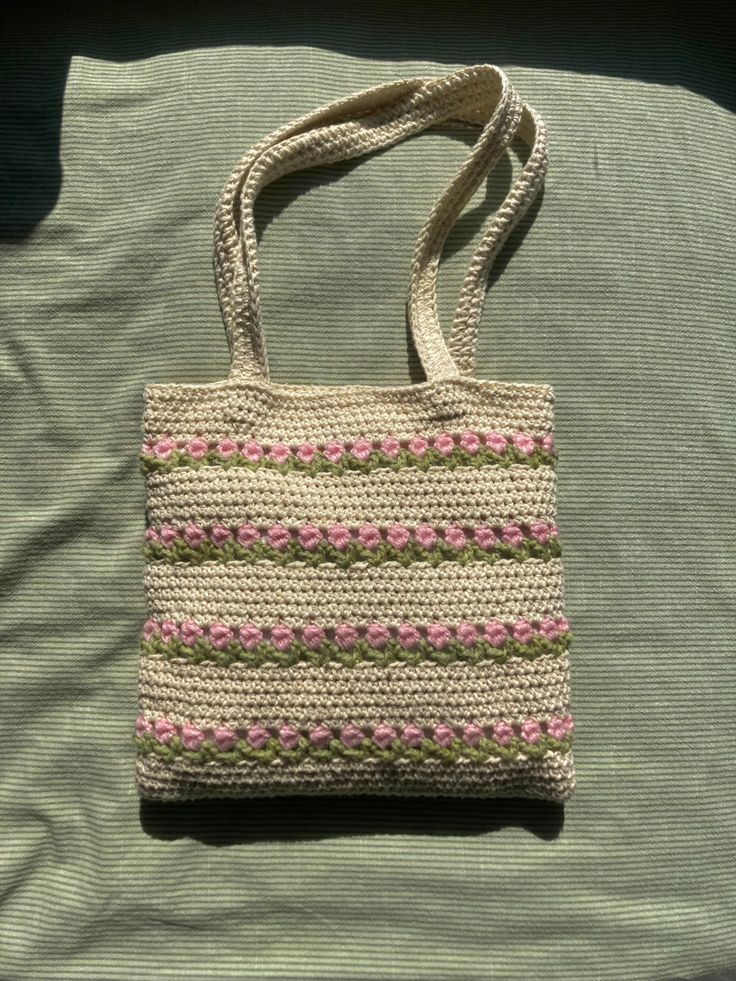 a crocheted bag sitting on top of a bed