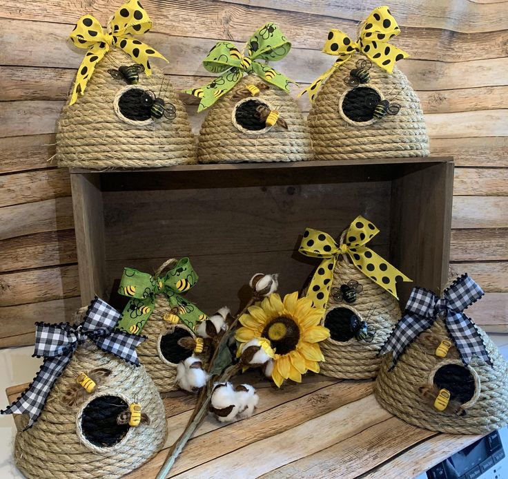 some baskets with sunflowers and other items in them on a shelf next to a wooden wall