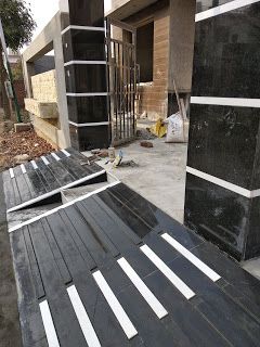 some black and white tiles are laying on the ground next to a building that is under construction