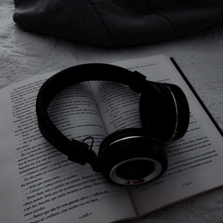 an open book with headphones on top of it