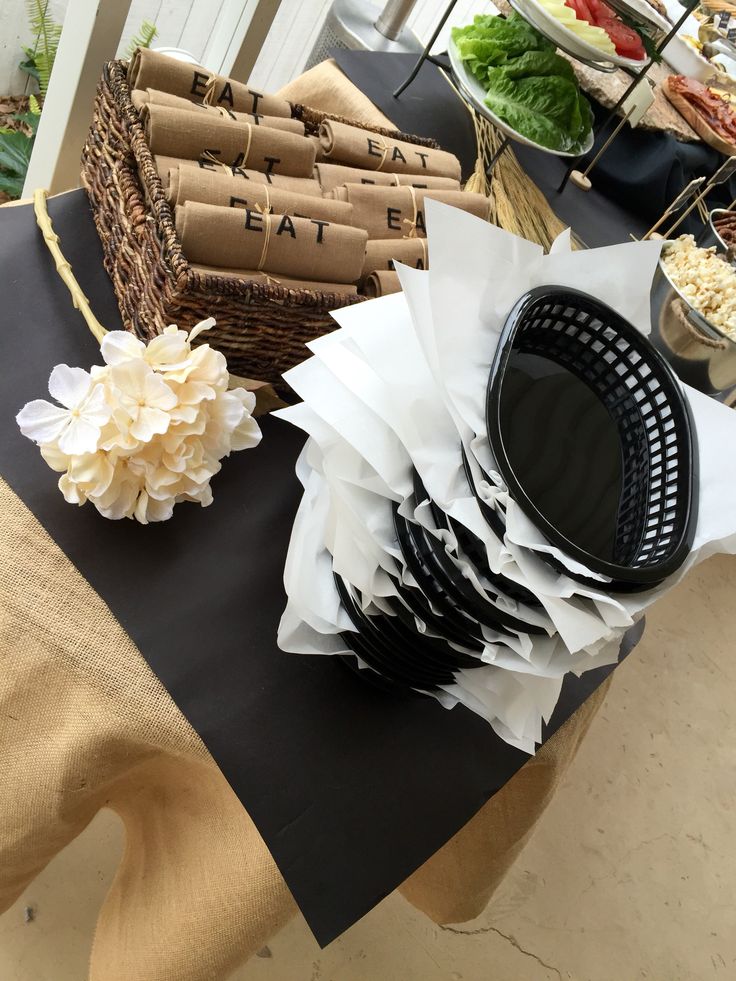 a table topped with lots of different types of food and paper bags on top of it