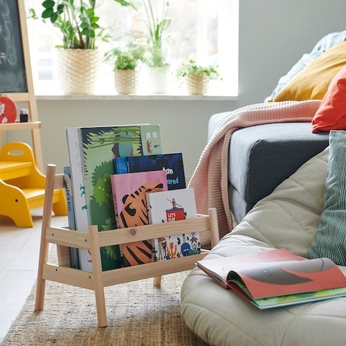 a living room filled with lots of furniture and books on top of a wooden stand