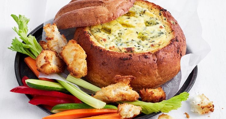 a plate with bread, vegetables and croutons on it next to some dipping sauce