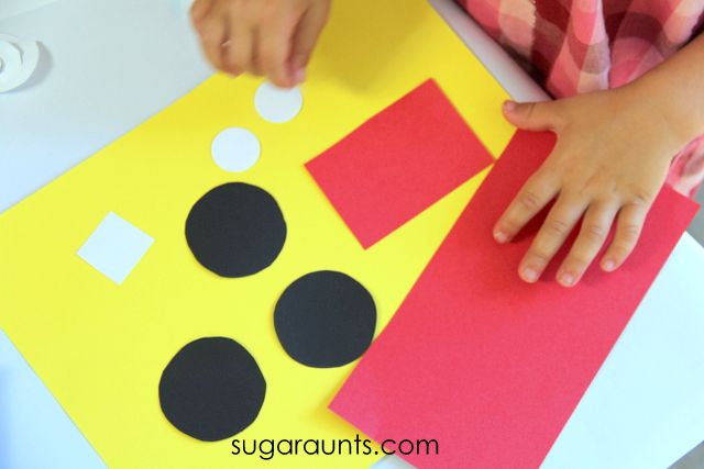 a young child is making a paper cut out of a construction site with black and white dots