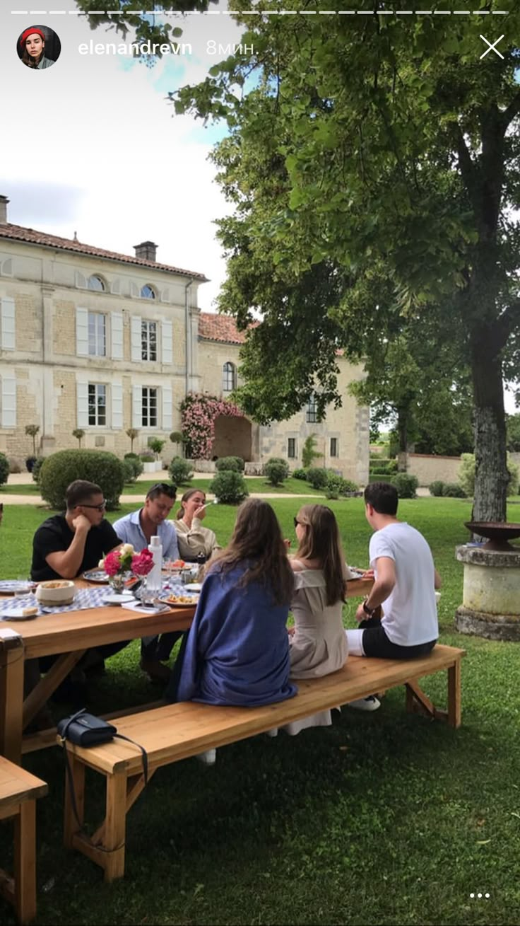 a group of people sitting at a picnic table