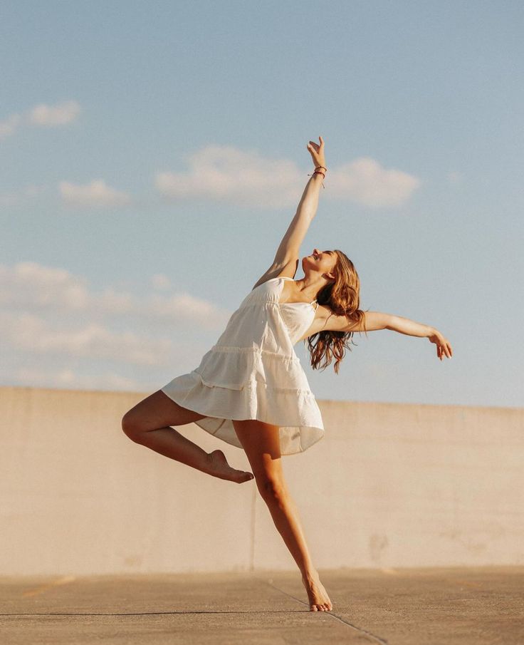 a woman in a white dress is doing a trick