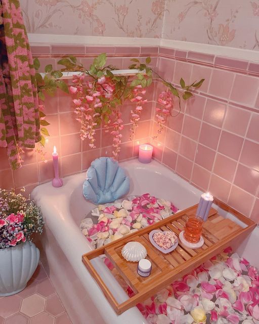 a bathtub filled with pink flowers and candles