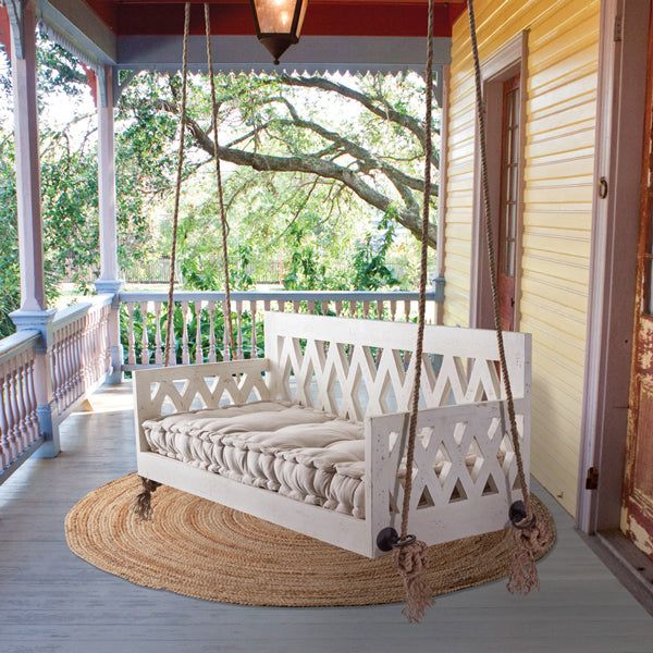 a porch swing that is hanging from the ceiling and has a pillow on top of it