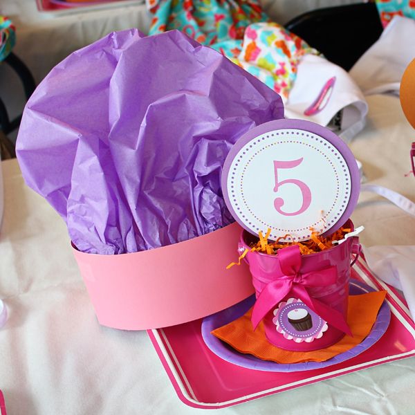 there is a purple hat on top of a pink box with the number five in it