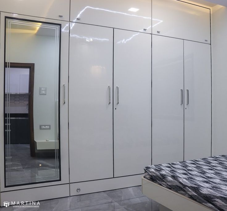 a bedroom with white cupboards and a black and white bed