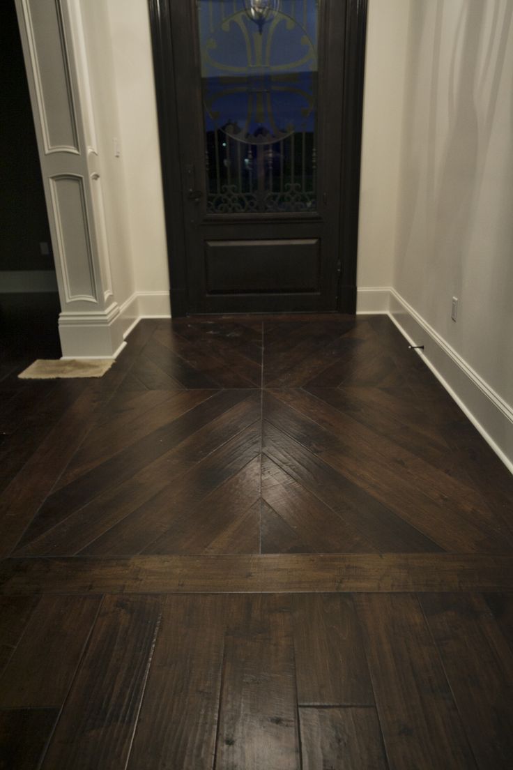 an empty room with wood floors and a black door