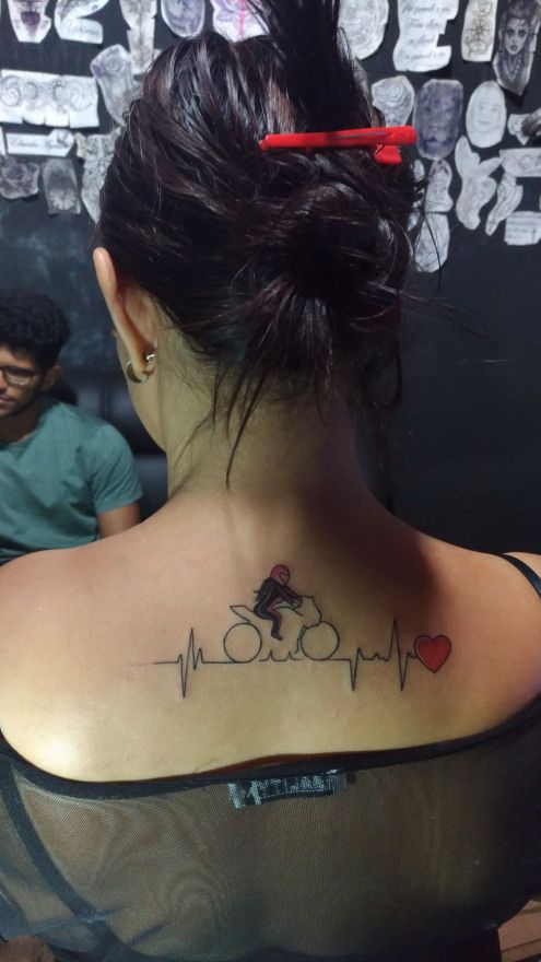 a woman with a heartbeat tattoo on her back