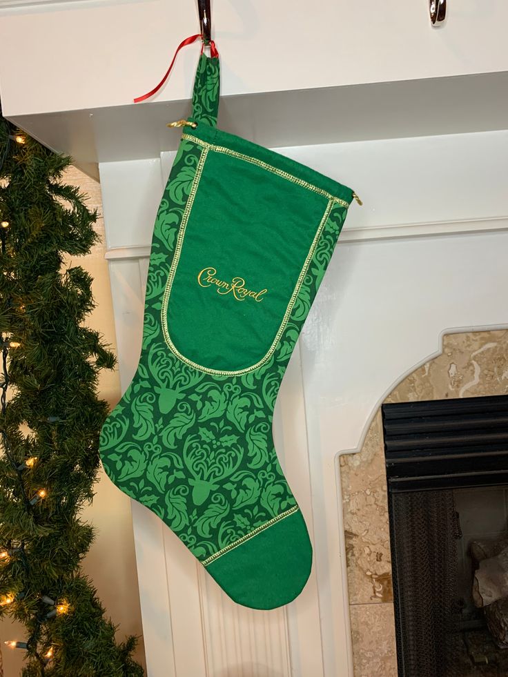 a green christmas stocking hanging from a fireplace