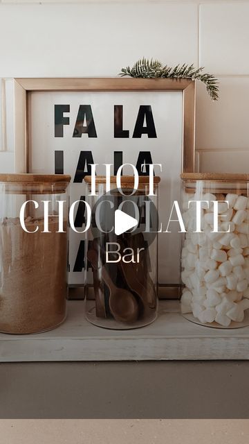 some jars and spoons are sitting on a shelf with the words fala la hot chocolate bar