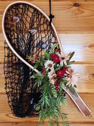 a bouquet of flowers in a net hanging on the wall