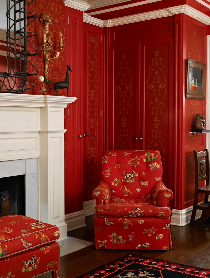 a living room with red painted walls and furniture in it, along with a fireplace