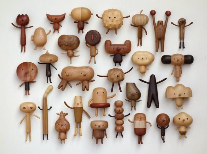 many wooden toys are arranged on a white surface