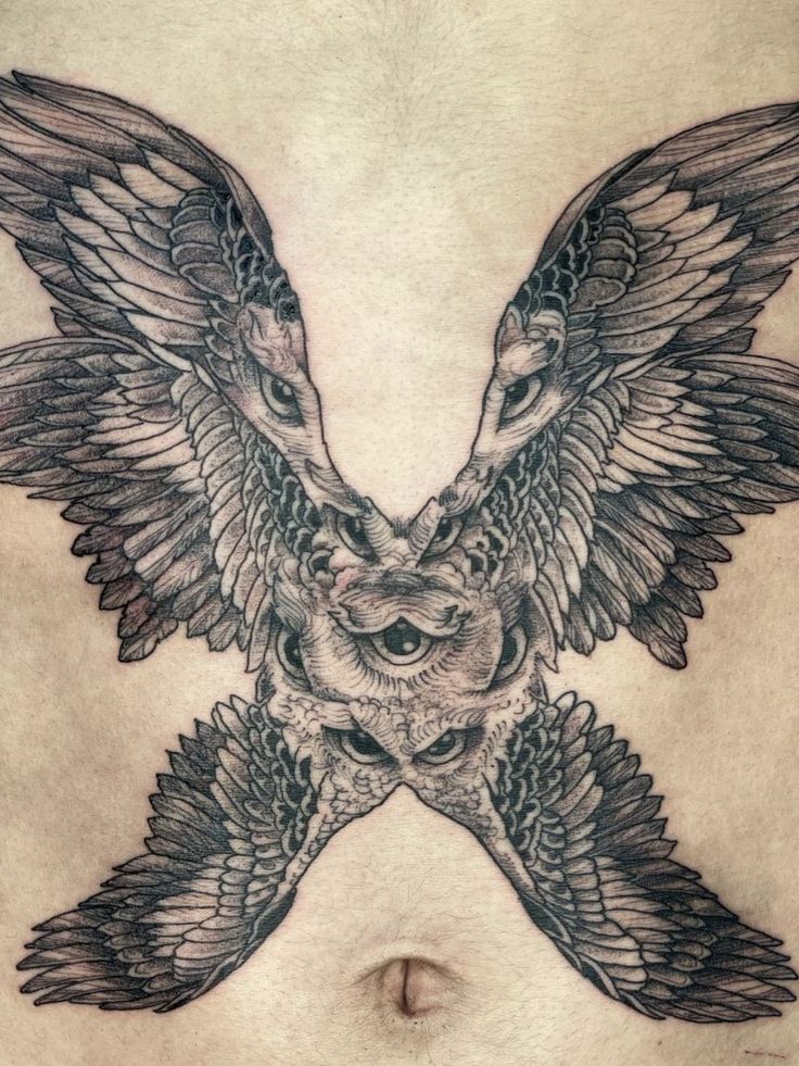 an owl tattoo on the side of a woman's stomach, with wings spread out